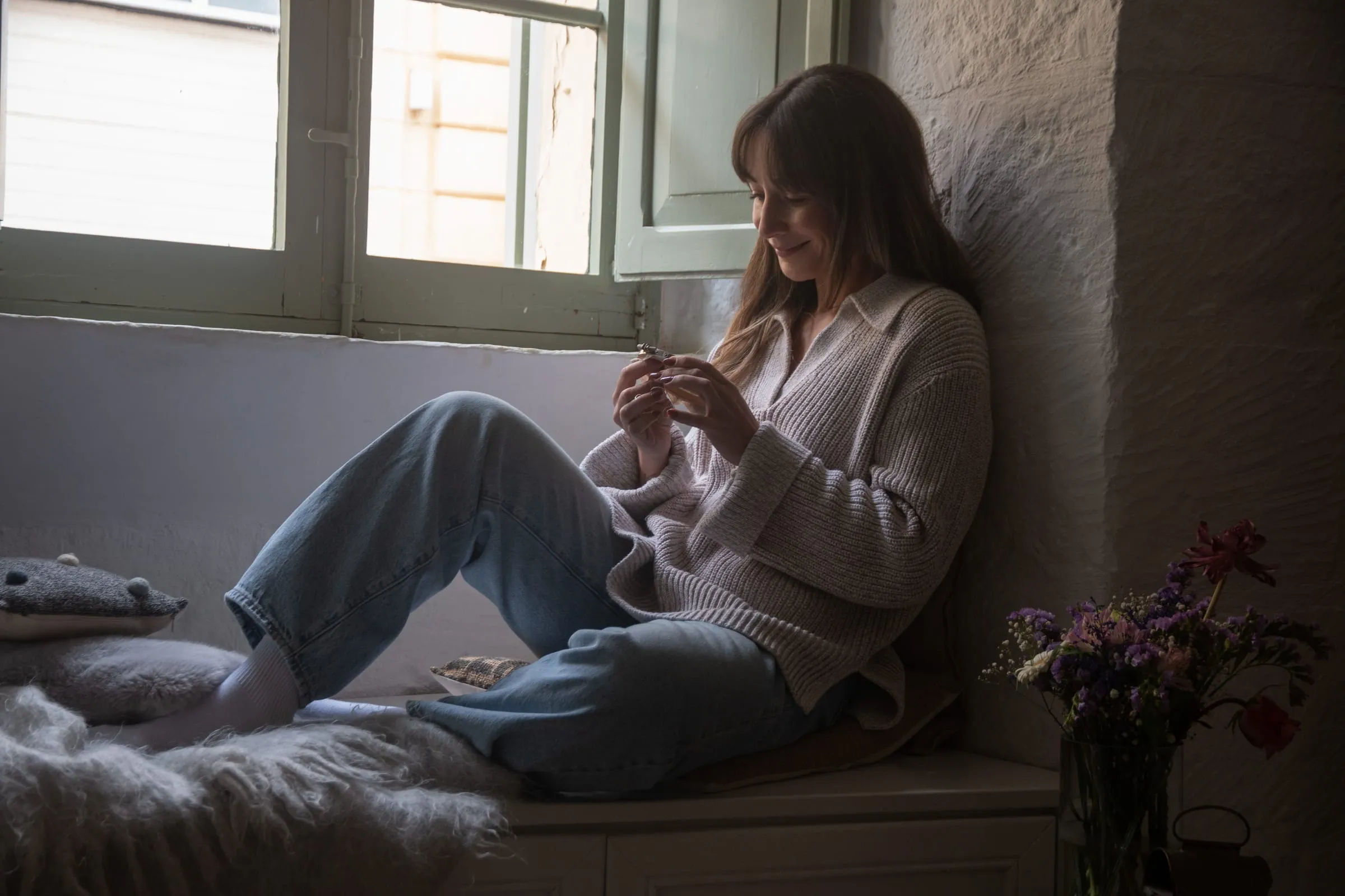 Sarah embroidering by a window in Gozo